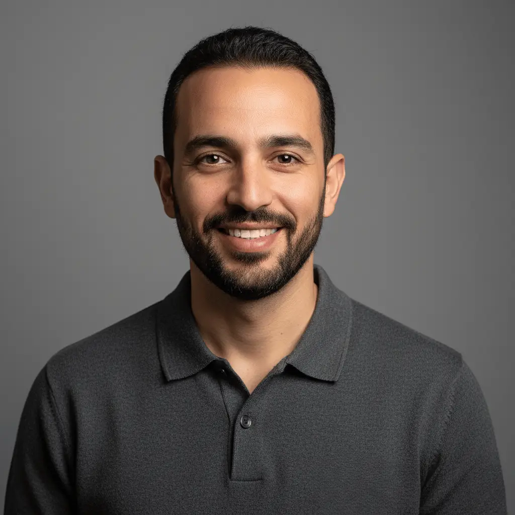 Portrait professionnel en studio de Amine Rachidi, l'expert technique de Visiona.ma. Il sourit et porte un polo gris.